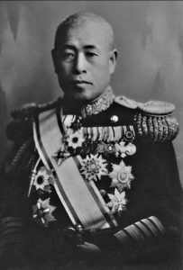 A bald man in uniform with several medals on it.