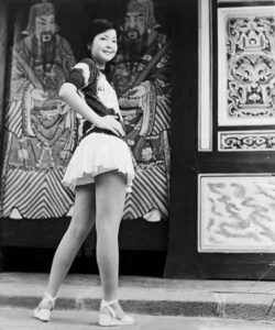 photo of a young woman posting in front of a traditional painting