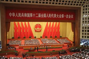 Photograph of a large auditorium with red and yellow background. 