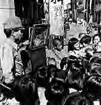 a man stands in front of a small stage and many people