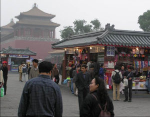 photo of tourists visiting a souvenir booth. in the distance is the view of a shrine