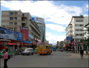 photo of a city. cars and a trolley can be seen driving on the road.