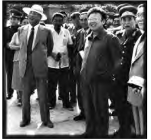 photo of several men in suits looking on at something beyond the camera