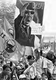 many people are in a group, holding banners and flags