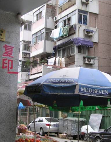 photo of a street market and high apartment buildings behind it