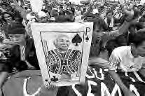 photo of a banner with a man on it, with many people standing behind it