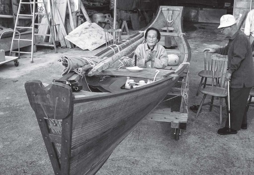 photo of a woman sitting in the wooden boat praying