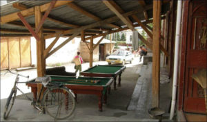 several billiards tables sit under the shade