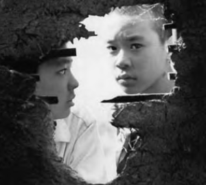 two boys peek through a hole in the wall