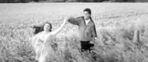 a girl and boy dance in a field
