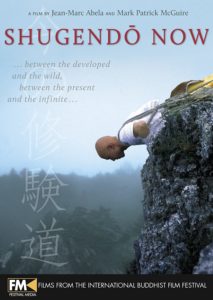 Film cover of Shugendō Now. The background photograph shows a middle aged man with rock climbing gear laying down, staring over cliff. 