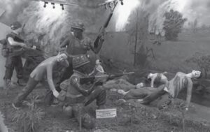 photo of a diarama showing people being shot by men in us military uniforms