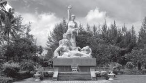 photo of a stone monument of people in mourning with a woman raising her fist in the air