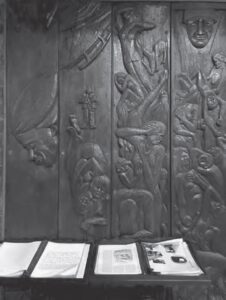 photo of a guest book and a carved relief of people suffering