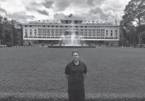 photo of a man in front of a large building with many rooms