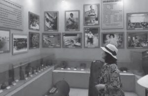 photo of a woman looking up at a wall covered in photographs