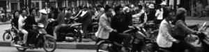 Photo shows many people riding motorcycle on busy street 