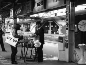 A girl is buying o bento (box lunch) on the train platform