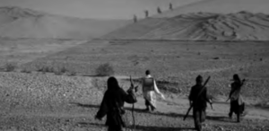 Photo of four man crossing the desert.