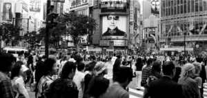 Image shows crowded pedestrian crossing in the shopping area.