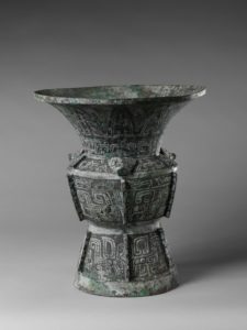 photo of a vase made of bronze. the vase is slightly geometric
