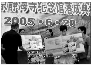 Two people holding a sign to celebrate the dedication ceremony for the Zheng He Memorial Hall