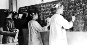 Images shows three female students are writing Chinese on balckboard