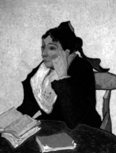 Image of a woman sitting on a chair with a book in her hand 