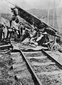 Photo shows refugees under a makeshift shelter on train tracks