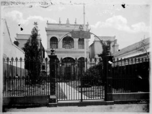 photo of a gate in front of a large victorian house
