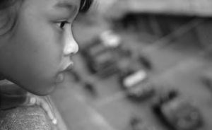 a child watches the soldiers march into the city from the balcony of her home.