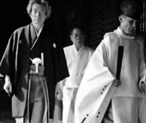 A man(Japanese Prime Minister Junichiro Koizumi )walking with two shriners
