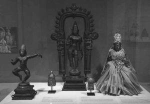 several bronze statues on display in a museum
