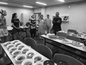 photo of people standing in front of many tables of food