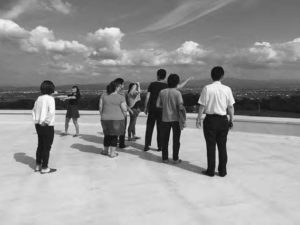 a photo of people standing on a roof looking out at the skyline