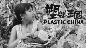 Promotional poster for Plastic China. The poster shows a photograph of a woman holding a baby amongst a sea of plastic waste. 