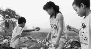 a young girl and two boys pick through plastic for toys
