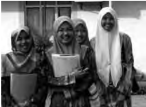 Photo of four Malaysian women smiling holding books in their hands