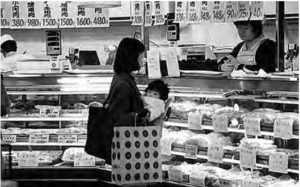 Photo of a mother holds her baby shopping in grocery