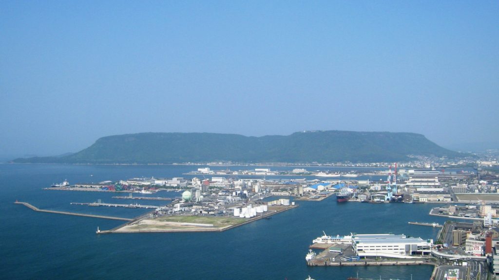 Contemporary photograph of Yashima; small coastal town with small mountains in the background. 
