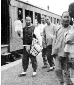 Image shows a person selling daily papers at a railway station