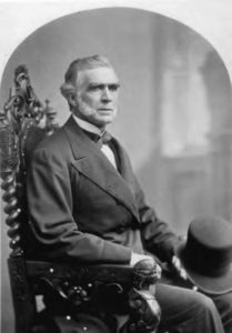 black and white portrait photo of a man with large sideburns.