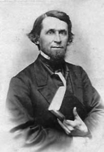 portrait of a bearded man holding a book.