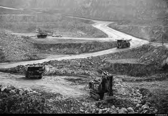 Work trucks move up and down a mining path. 