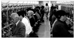 Two rows of people playing pachinko machines