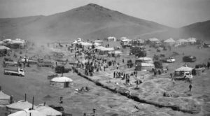 Landscape photograph of a camp of people with yurts and trucks. These are members of the Ninja gold camp. 