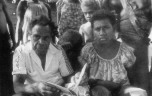 Image of one man and woman sitting in front of crowd
