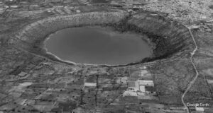 a photograph from aerial view of a crater with water in it