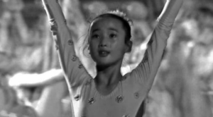 Screen capture of a girl hands up during mass Games performance