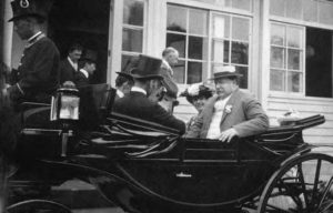 photograph of men sitting in the back of a stage coach